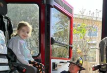 
			
				                                Grace Serafin is delighted to sit in a real firetruck, assisted by Assistant Fire Chief David Granteed.
                                 Submitted Photo

			
		